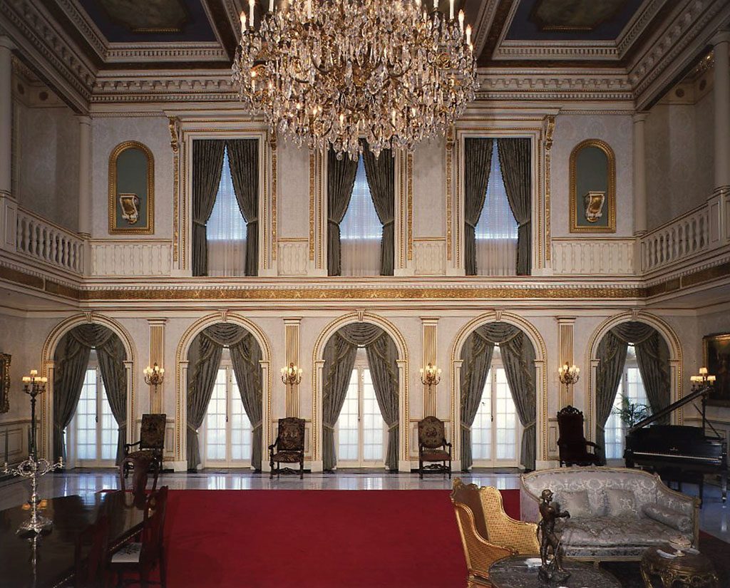 French style music room with elaborate gilded moulding, arched windows
