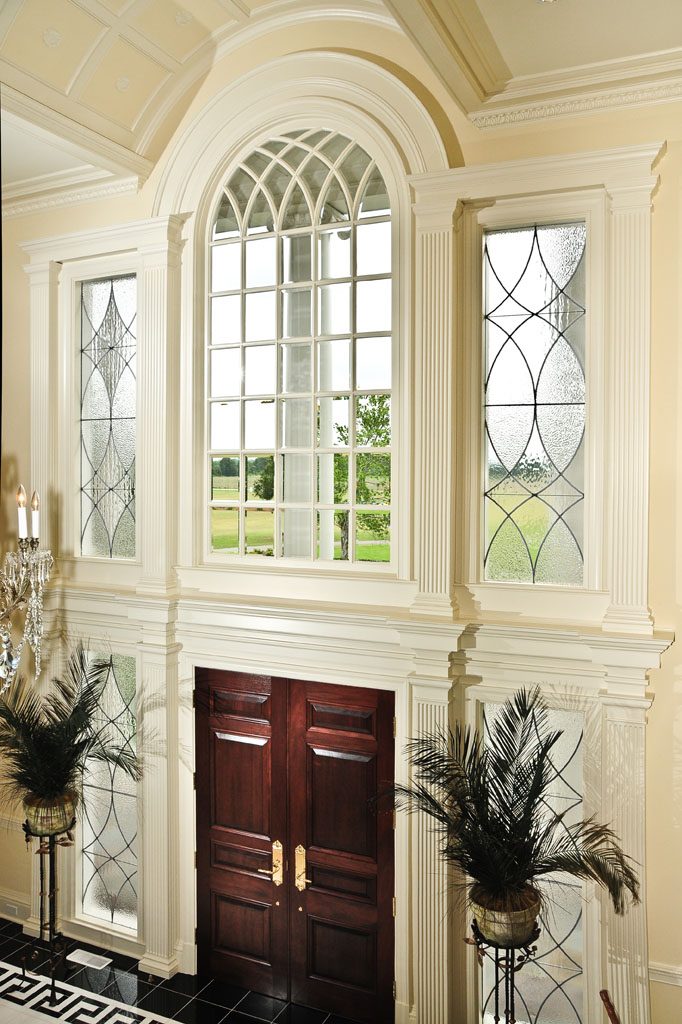 Palladian overdoor entrance way with grand pilasters and paneled ceiling.